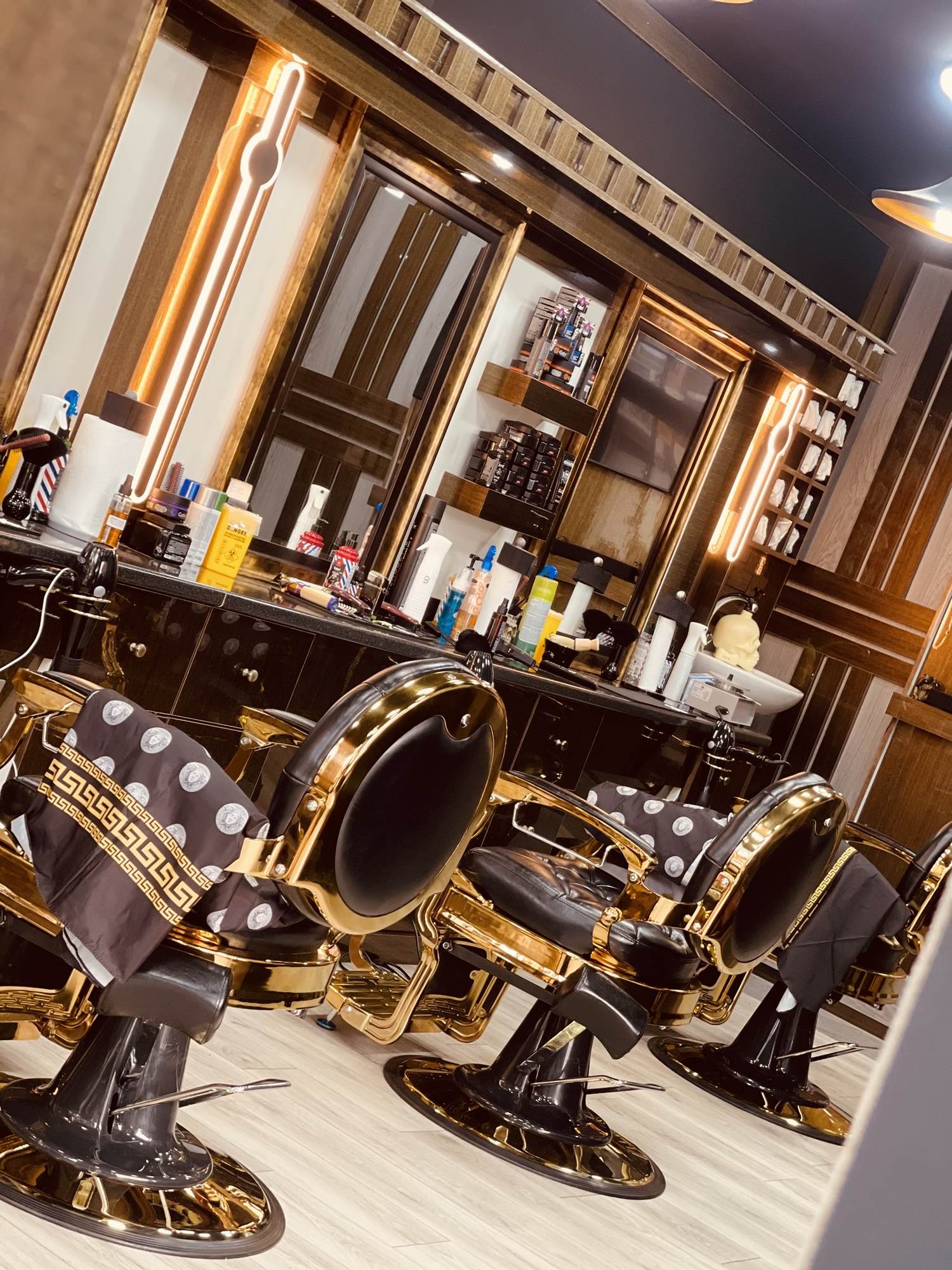 Row of gold and black barber chairs inside Bstar Barber, Plaistow