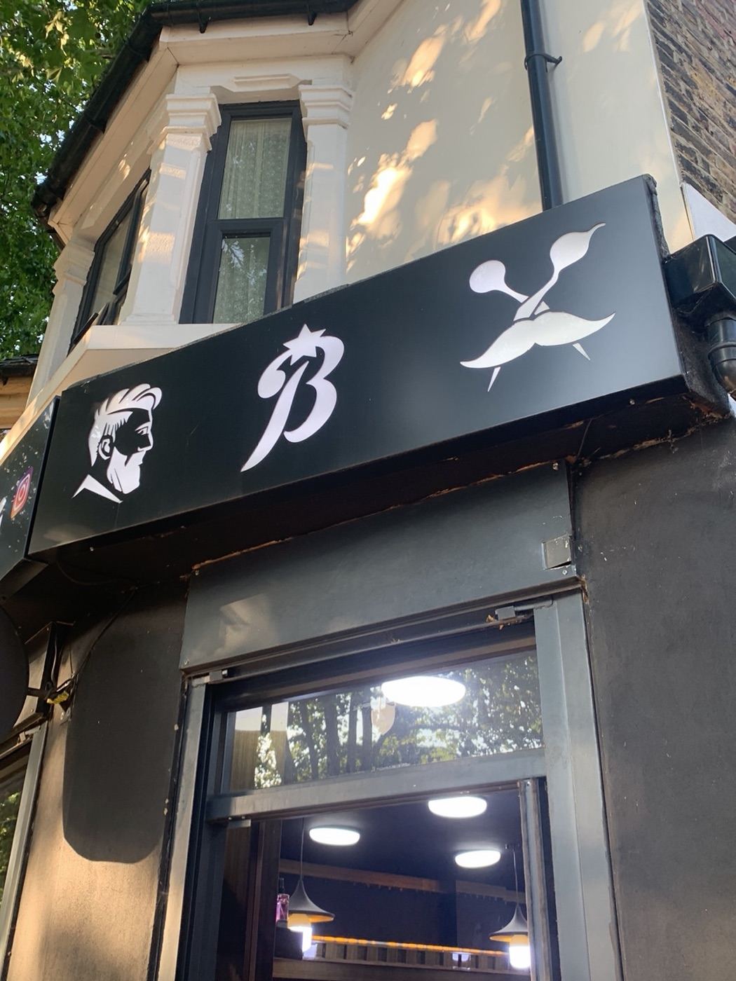 Bstar Barber fascia sign with the barber, B and scissors marks above the entrance